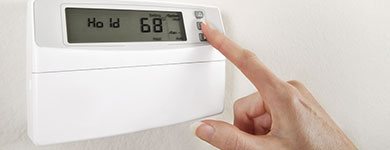 Save heating bills Someone adjusting a thermostat